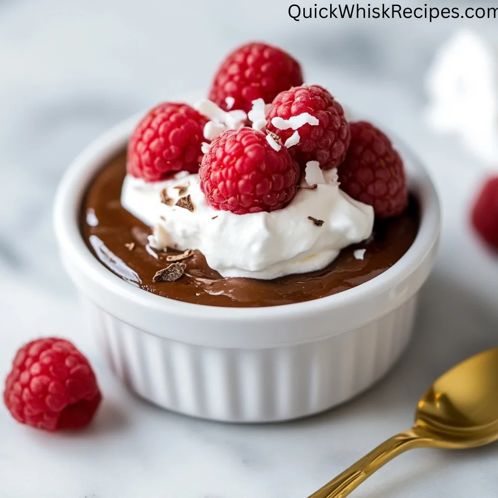 Creamy chocolate tofu pudding garnished with whipped cream, raspberries, coconut flakes, and chocolate shavings in a white ramekin.