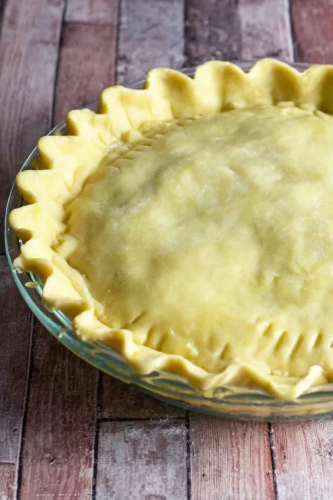 Unbaked mince and cheese pie with crimped pastry edges in a glass pie dish