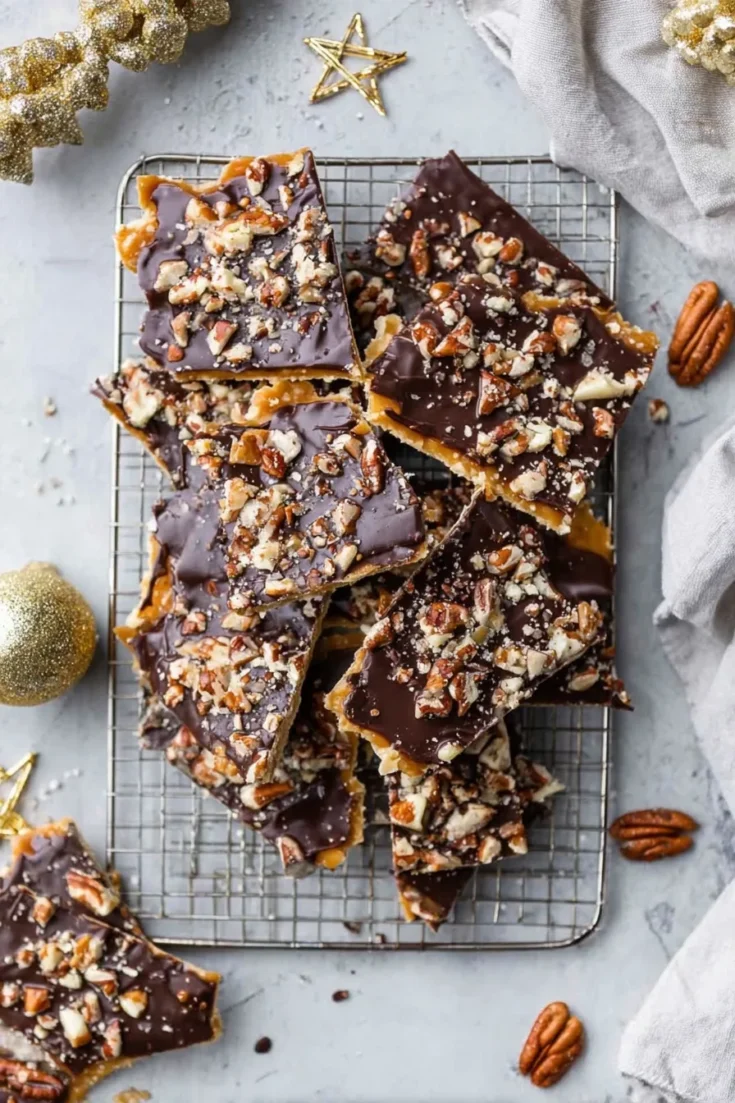 Pieces of Christmas crack with chocolate and pecans on a cooling rack, ready to serve