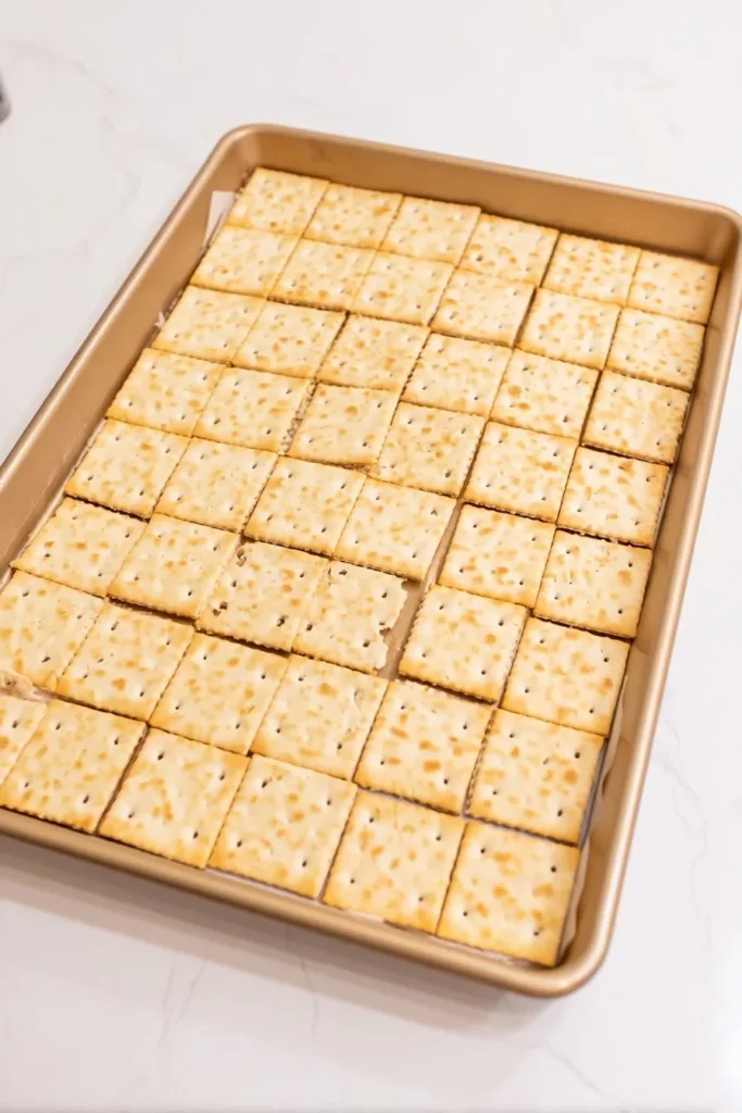 Saltine crackers neatly arranged on a baking sheet for Christmas crack recipe