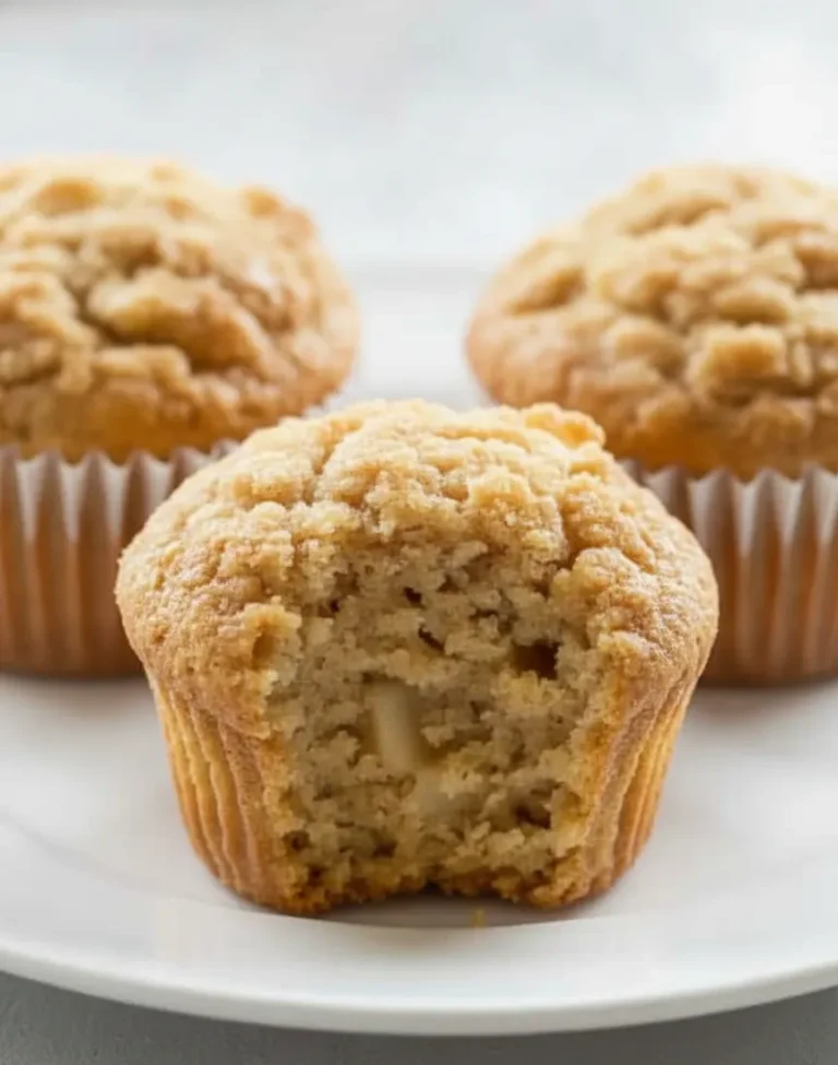 Close-up of baked apple muffins with crumb topping and soft texture.