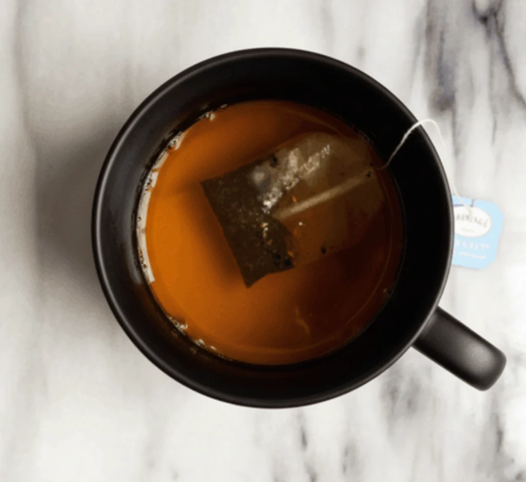 Earl Grey tea steeping in a black mug for homemade London Fog Tea.