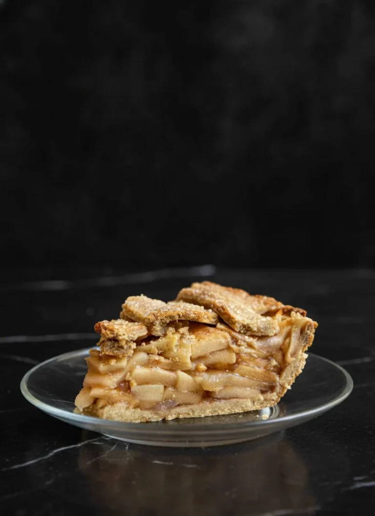 Close-up of a slice of homemade no-sugar apple pie showing layers of baked apples and flaky crust.