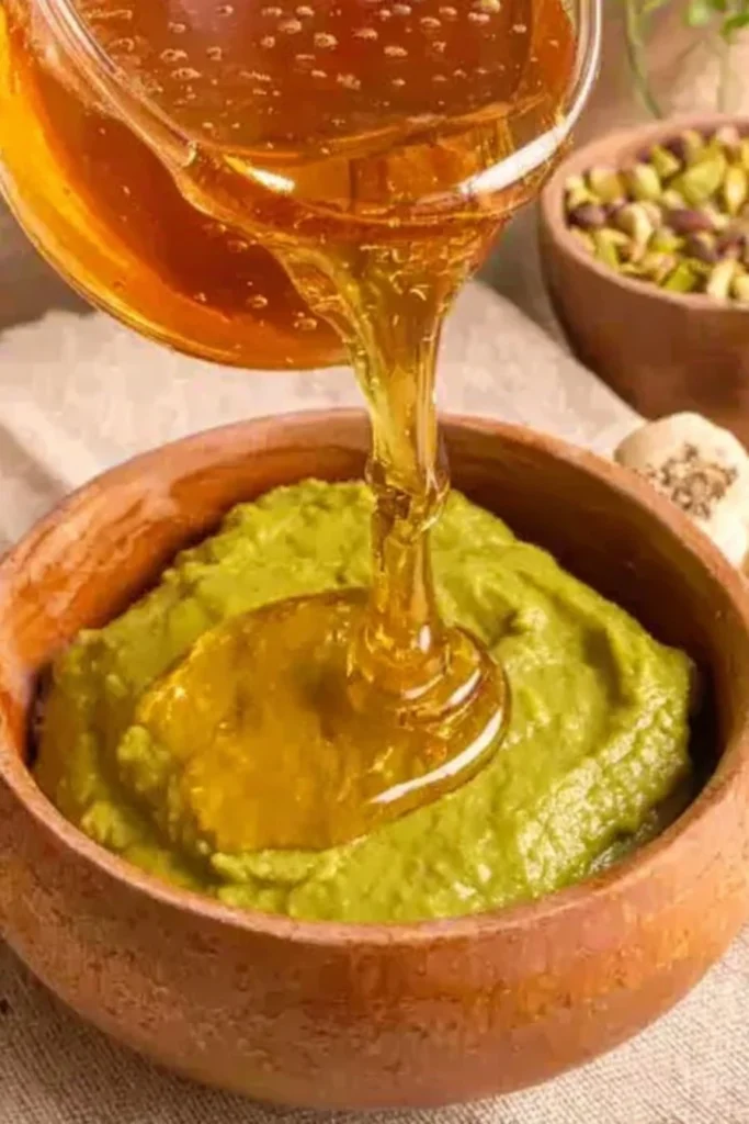 Honey being poured over pistachio butter mixture for pistachio truffles