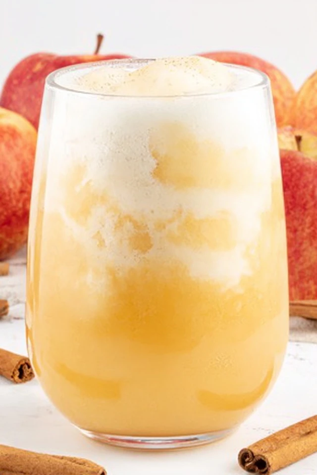 Creamy apple cider float made with vanilla ice cream, served in a glass with fresh apples and cinnamon sticks