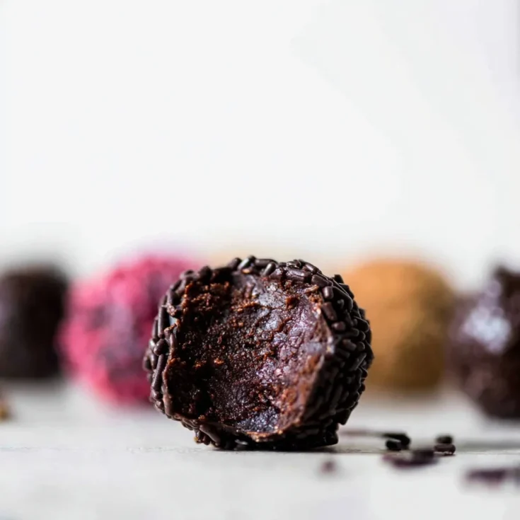 Close-up of a bitten homemade chocolate truffle with a rich, creamy ganache center and chocolate sprinkles, perfect for an easy chocolate truffles recipe.