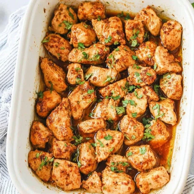 Golden oven-baked chicken pieces garnished with fresh herbs