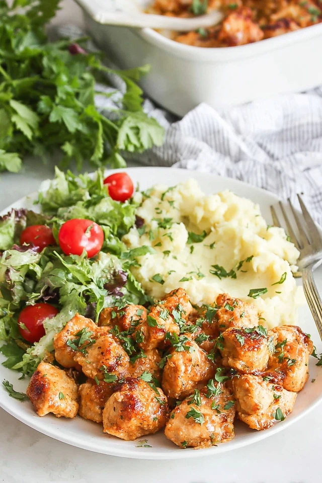 Oven-baked chicken pieces served with mashed potatoes and fresh salad