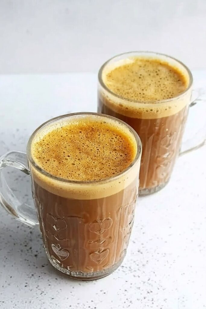 Creamy banana milk coffee served hot in clear glass cups with smooth foam