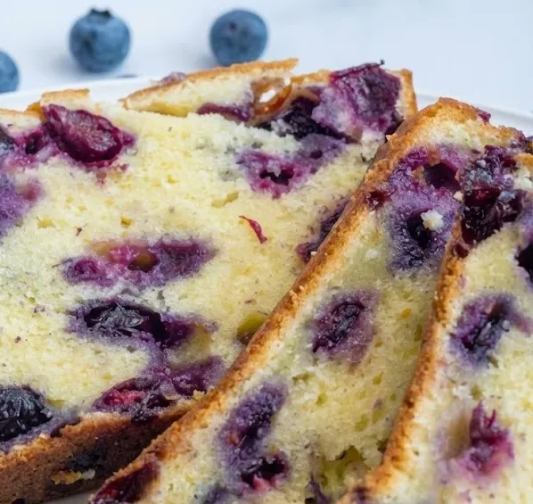 Moist blueberry cream cheese loaf sliced, showing creamy texture and juicy blueberries