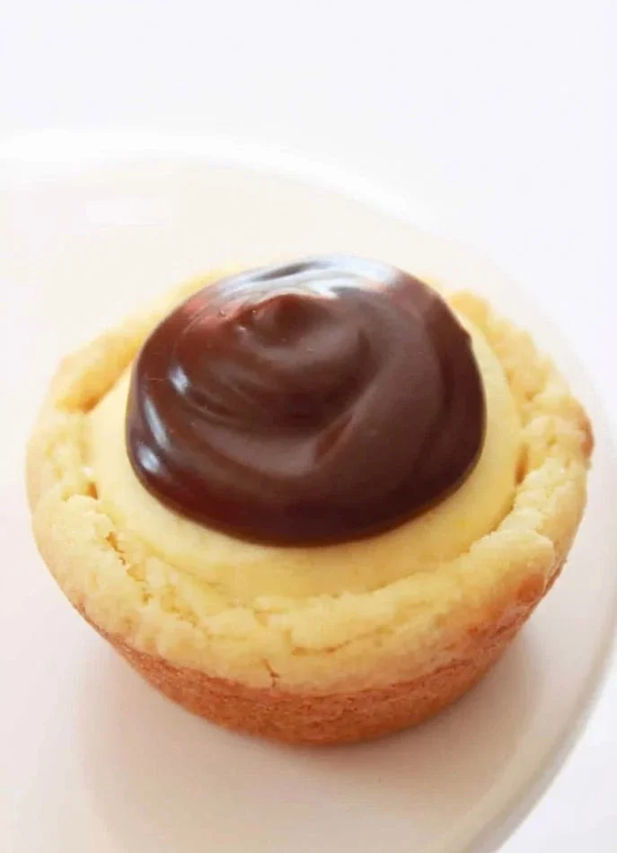 Boston cream pie cookies topped with chocolate and creamy vanilla filling