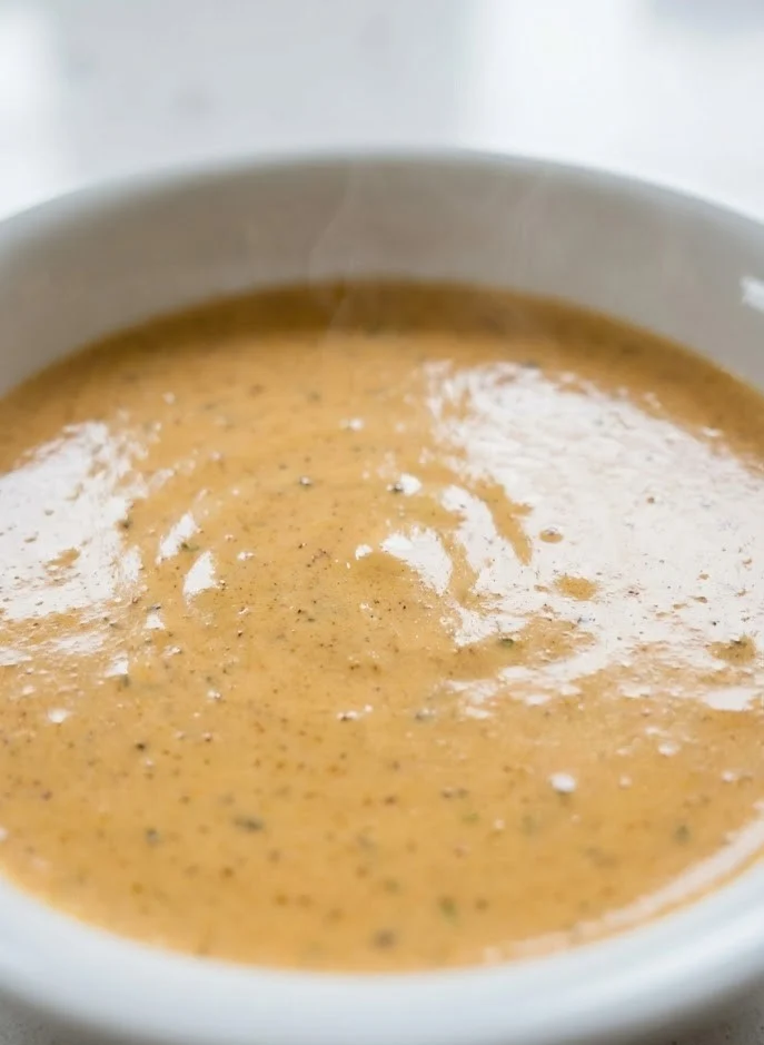 Creamy Cajun Alfredo sauce in a bowl with smooth glossy texture and visible Cajun seasoning