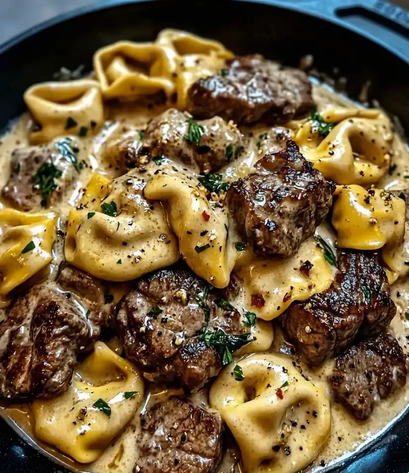 Cracked garlic steak tortellini in creamy Creamhouse sauce served in a skillet, close-up view