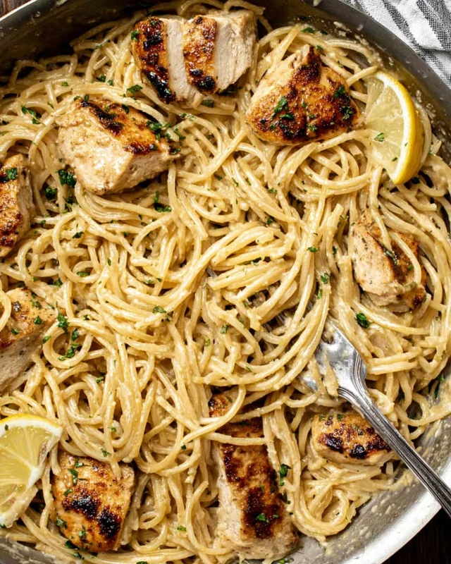 Creamy cowboy butter chicken pasta in a skillet with golden chicken, garlic butter sauce, and lemon