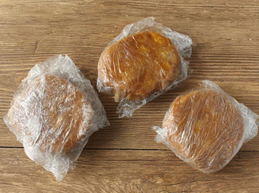 Gingerbread cookie dough portions wrapped in plastic wrap and chilling before baking