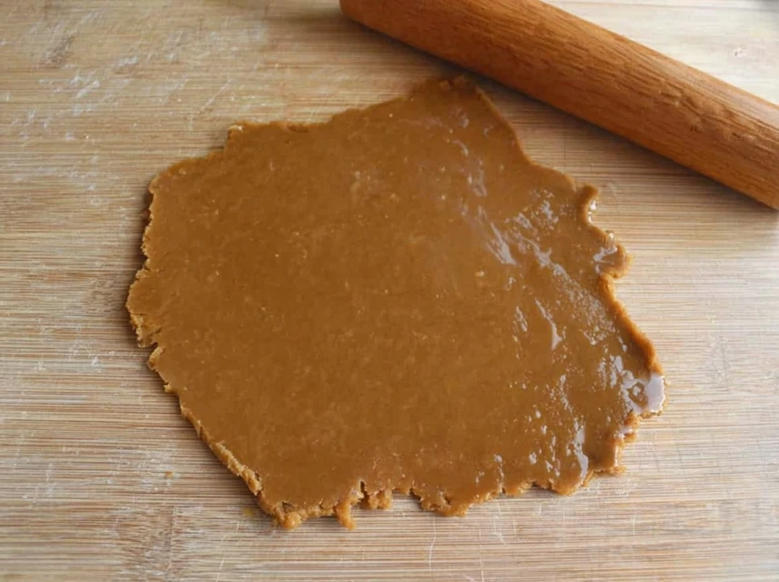 Rolled out gingerbread cookie dough on a wooden surface ready for cutting