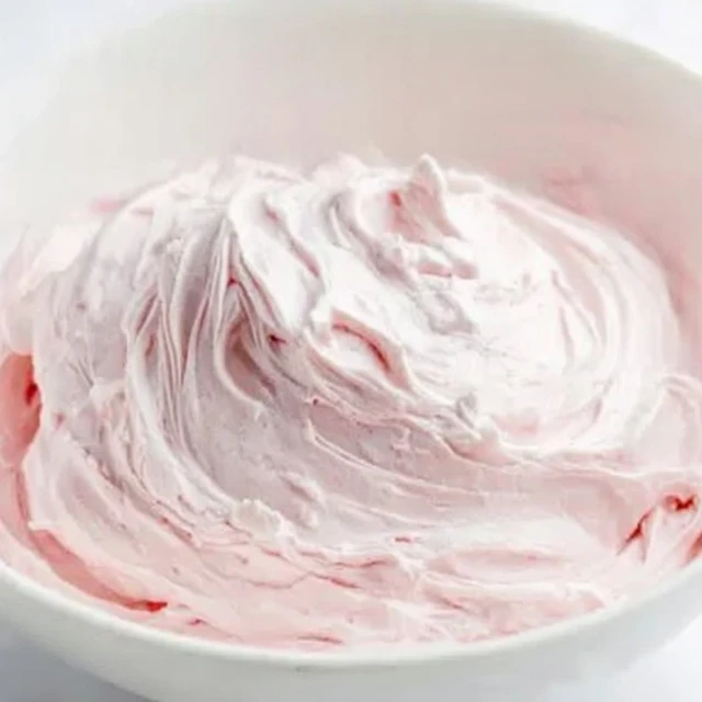 Creamy strawberry marshmallow frosting with soft whipped texture in a white bowl