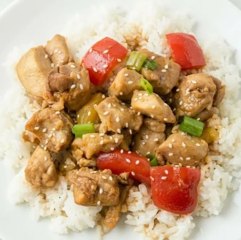 Sweet Hawaiian crock pot chicken served over white rice with pineapple, bell peppers, green onions, and sesame seeds