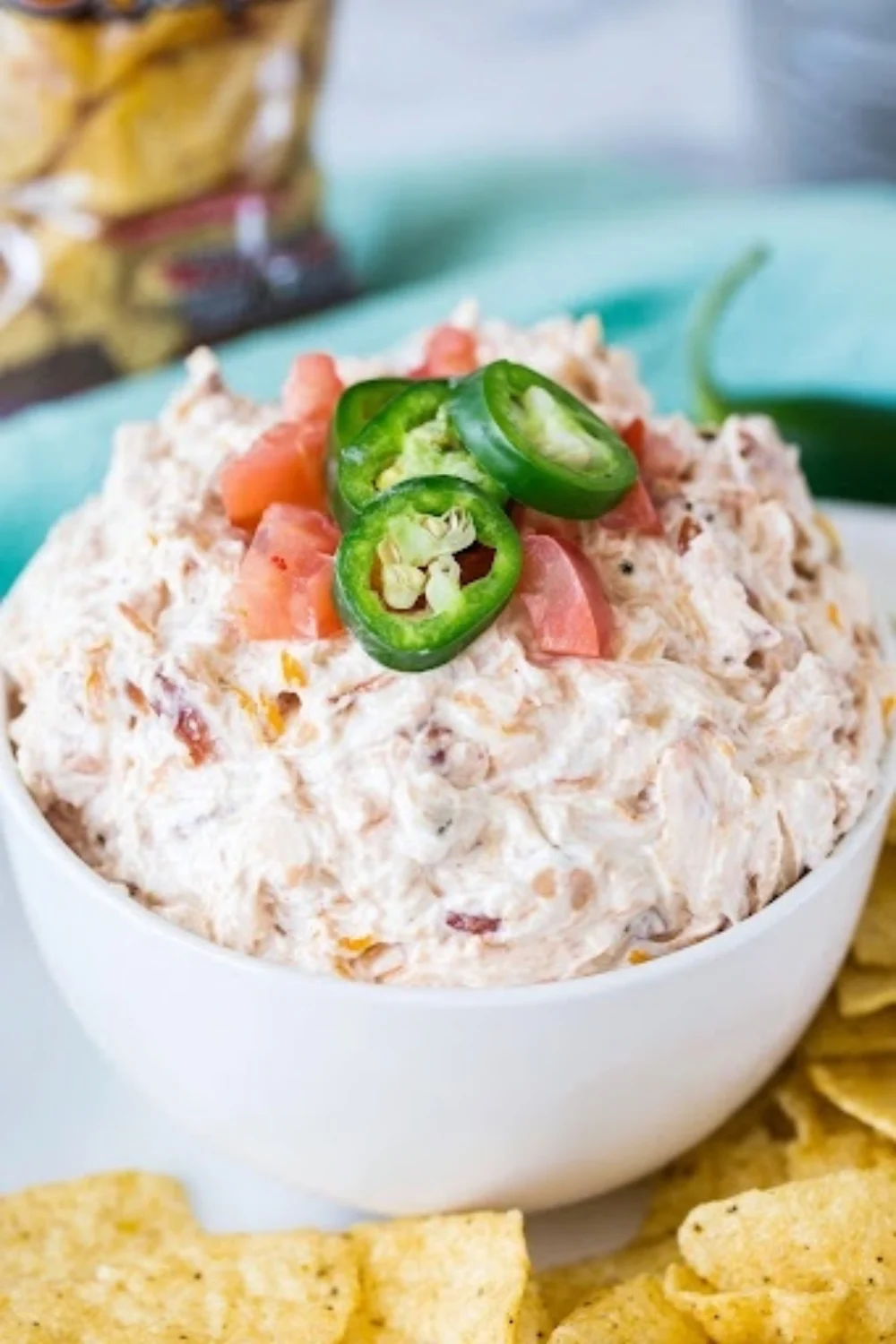Boat Dip Rotel Ranch Dip in white bowl topped with jalapeños and tomatoes served with tortilla chips