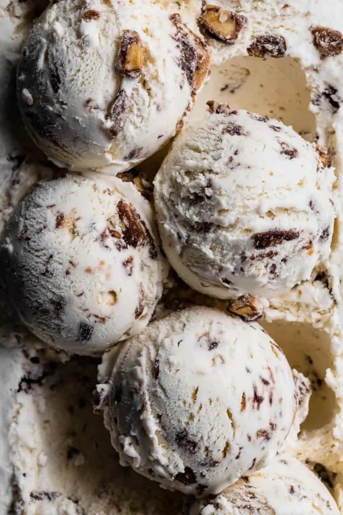 Close-up macro shot of Browned Butter Pecan Ice Cream scoops showing the rich texture and toasted pecan chunks.