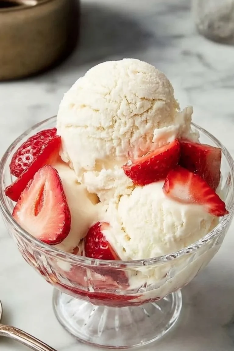 Gourmet vanilla ice cream served in a crystal glass bowl with fresh red strawberries.