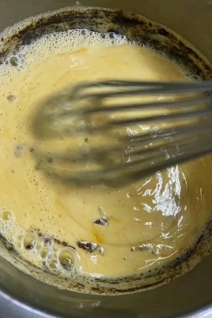 Whisking a bubbling amber sugar and syrup mixture on the stove to create crunchy honeycomb.